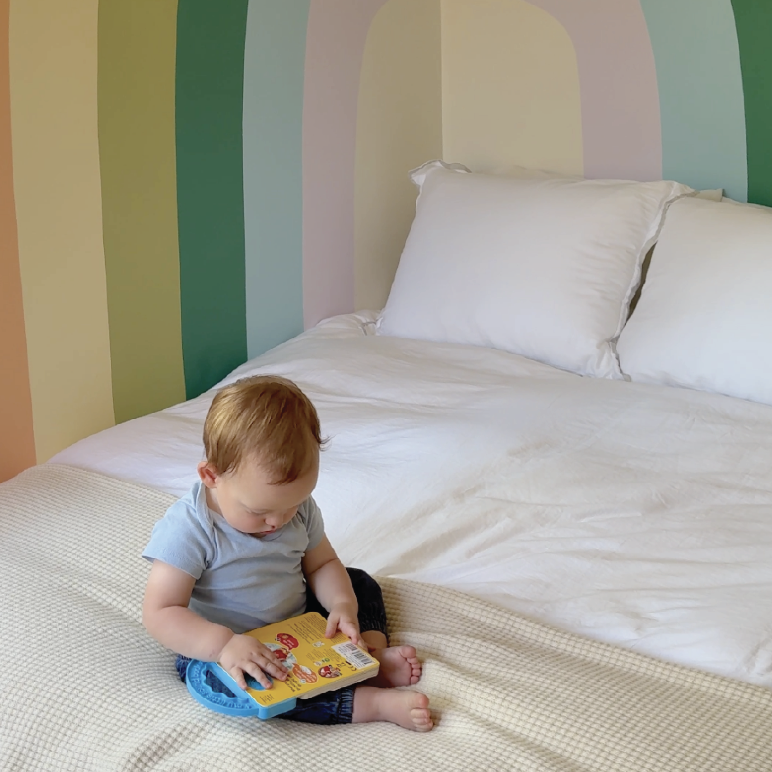 Calm neutral nursery with rainbow mural and minimalist décor