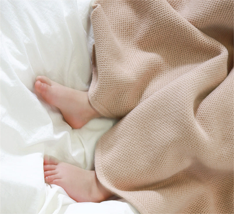 Baby girl's feet in beige, plant dyed merino baby blanket. Sustainable, non-toxic baby blanket.