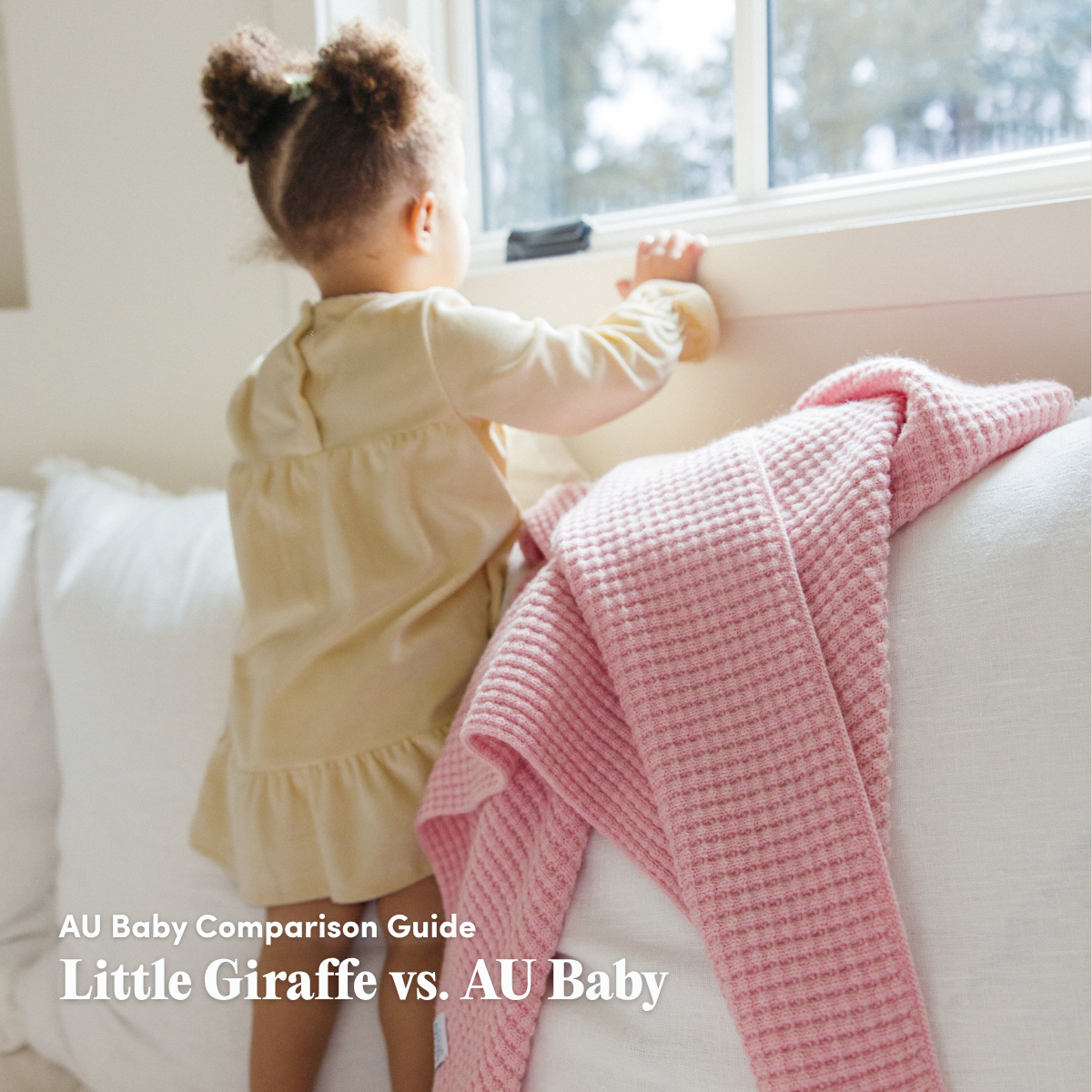 Toddler with a pink merino wool baby blanket by AU Baby, featured in the AU Baby Comparison Guide comparing Little Giraffe and AU Baby.