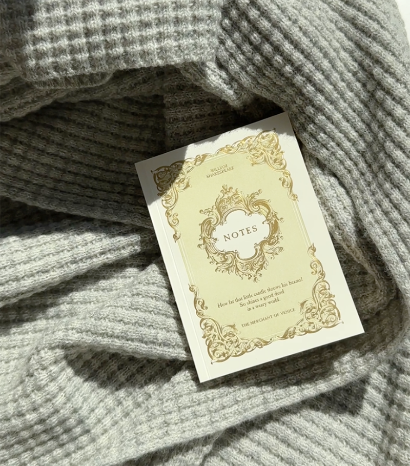 A journal on a grey, plant dyed merino AU Baby throw blanket 
