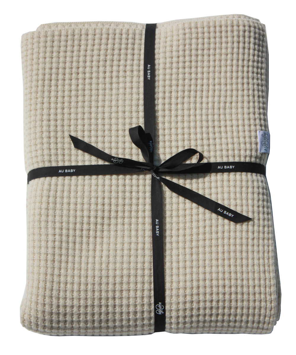 AU Baby Adult Popcorn blanket in Cream, folded and tied up with a black ribbon. A soft, cozy folded 100% plant dyed extrafine merino throw blanket.