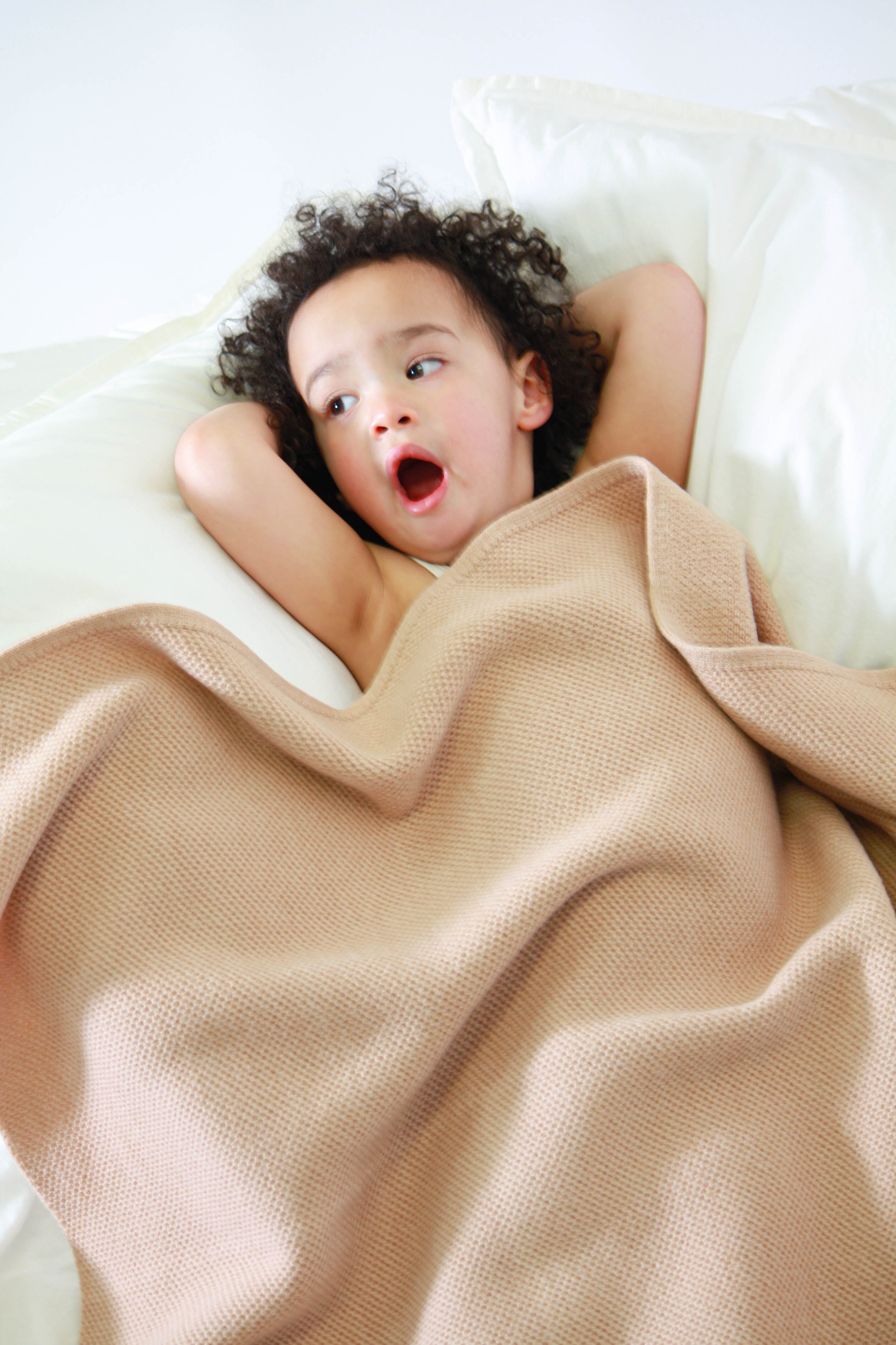 Little girl relaxing in an AU Baby merino baby blanket.