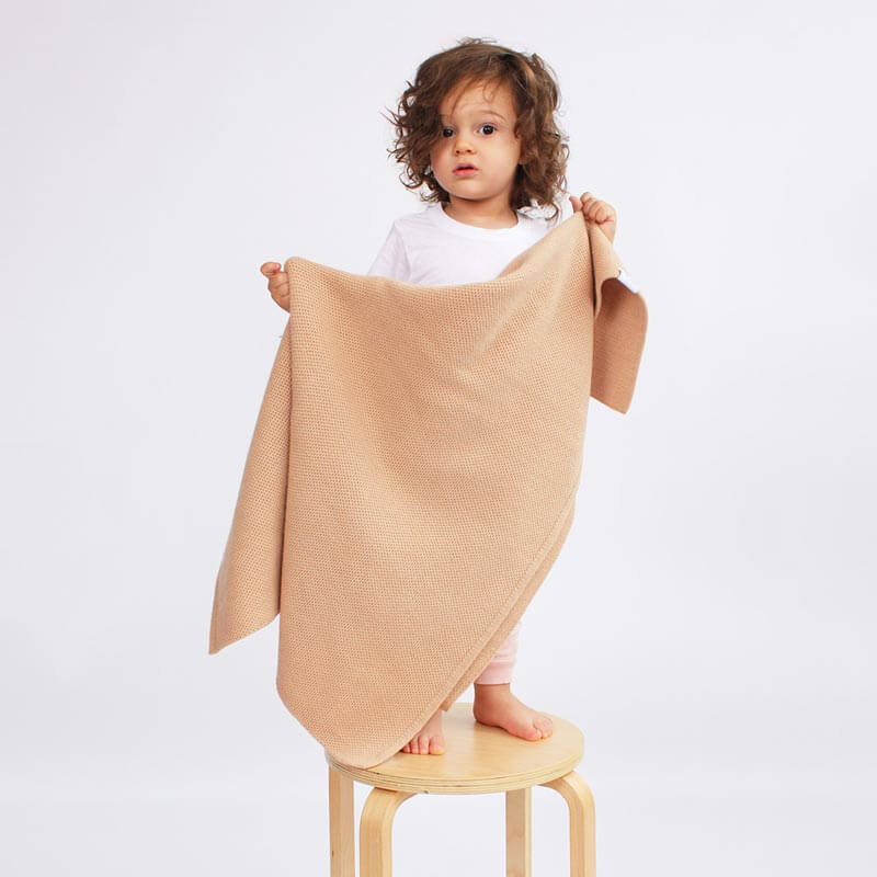 Little boy holding AU Baby Sawa blanket in Henna. Non-toxic, natural baby blanket.